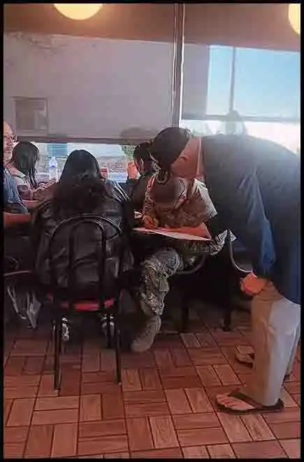 While eating at Waffle House, author David Haave signs books for a graduating soldier from basic training; Ft Wood, MO, USA -- David Haave